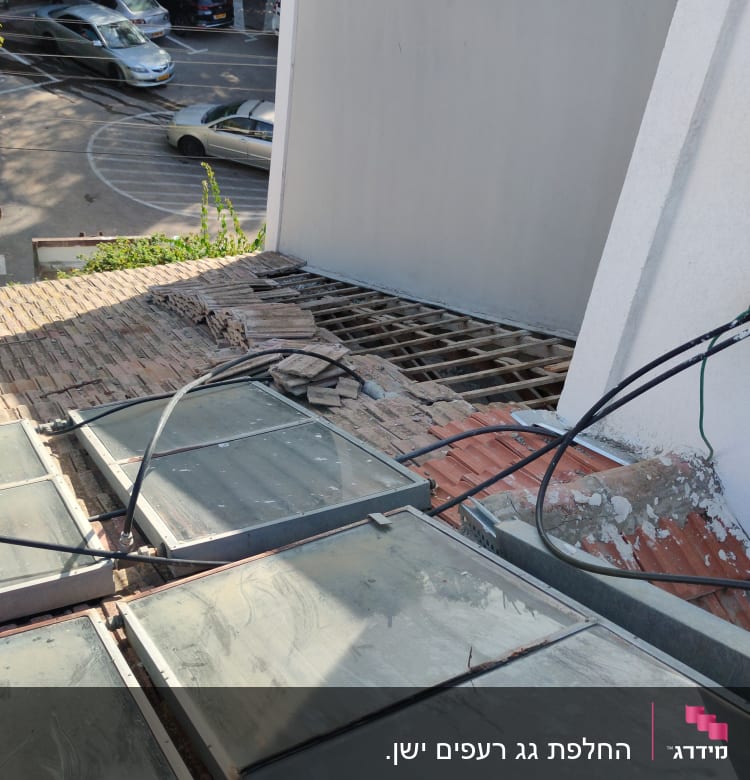 גג עם רעפים שבורים וחלונות זכוכית